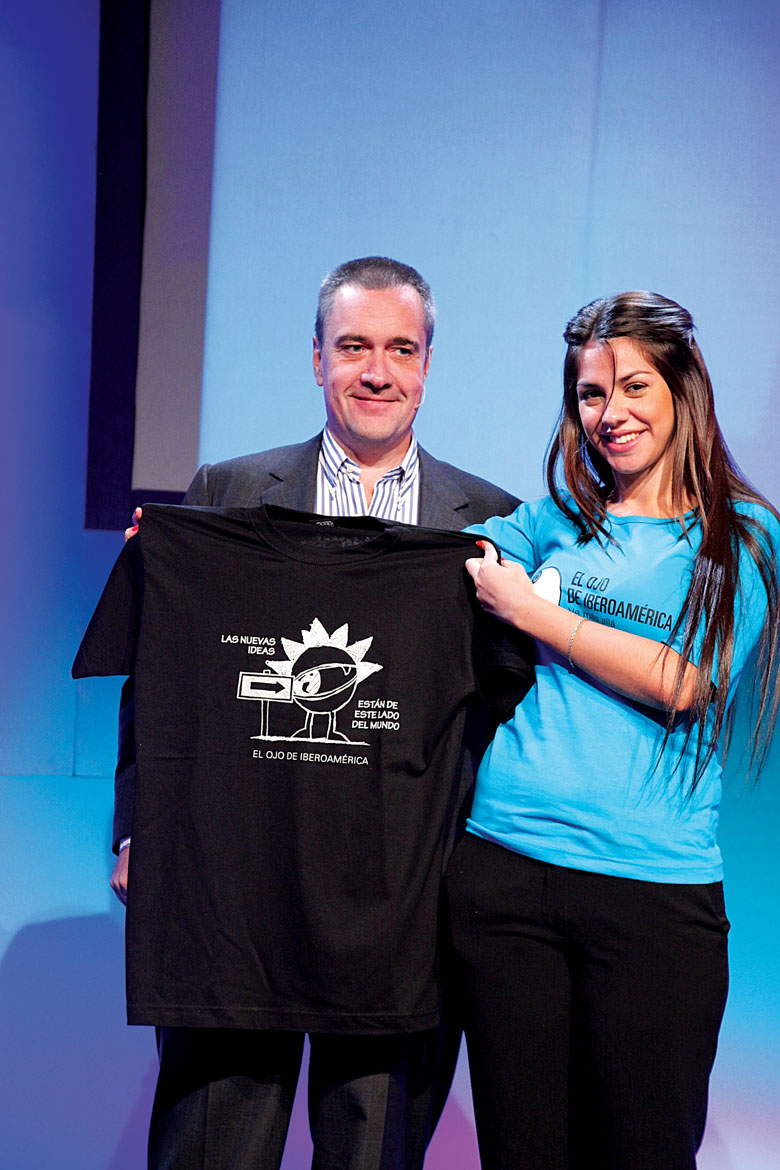 Luca Lindner recibe uno de los obsequios de El Ojo a sus conferencistas, una remera con el logo del festival